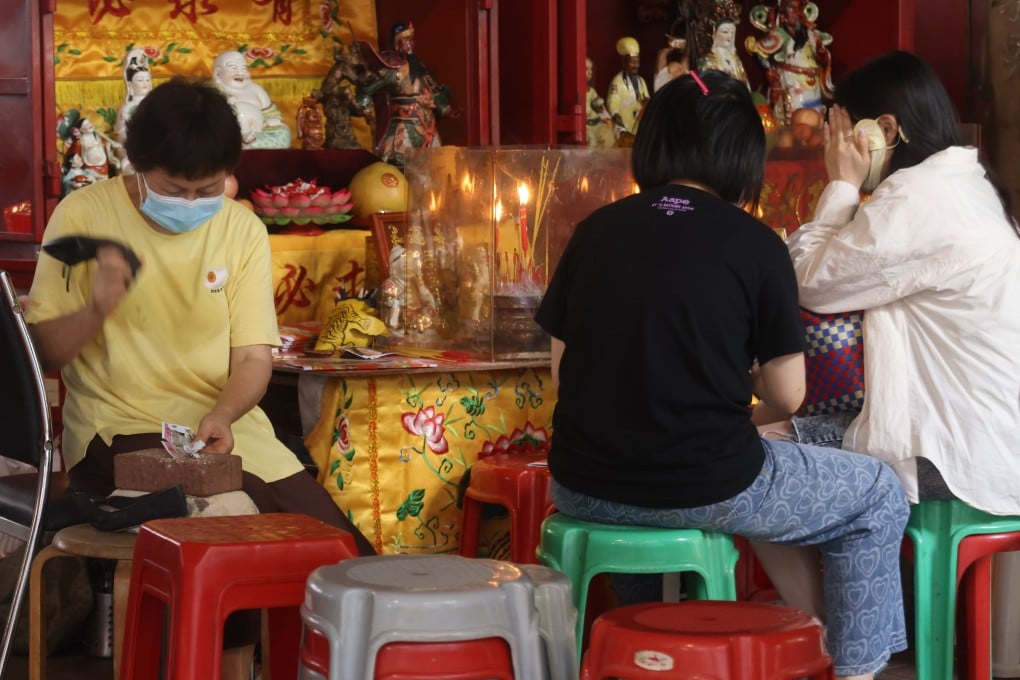 A practitioner performs a villain-hitting ritual in Causeway Bay, Hong Kong. Fortune-tellers break down the practice and explain its history. Photo: Jonathan Wong