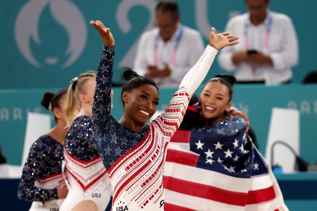 Simone Biles (centre) celebrates winning gold with the United States in the team competition. Photo: Reuters