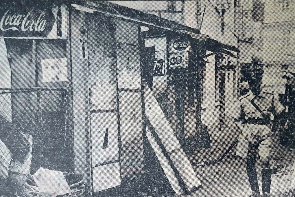 A police officer outside the grocery store where two brothers and their cousin were murdered in 1958. Photo: SCMP Archive