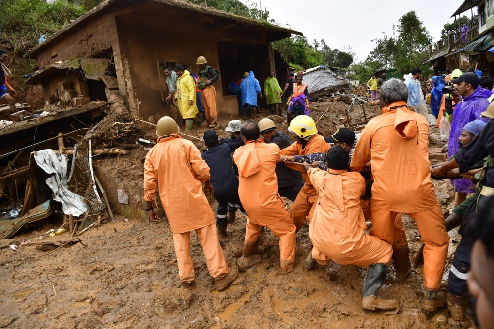 People try to remove a tree trunk as search and rescue operations continue following landslides in Kerala, southern India on July 31. Photo: EPA-EFE