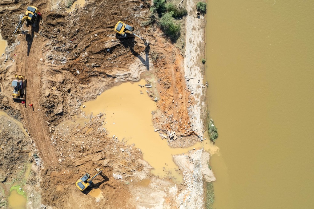 Emergency workers repairing a breached dike in the Juanshui River in central China’s Hunan province on Wednesday. The breach occurred on Sunday after heavy rainfall hit the province. Photo: Xinhua/EPA-EFE