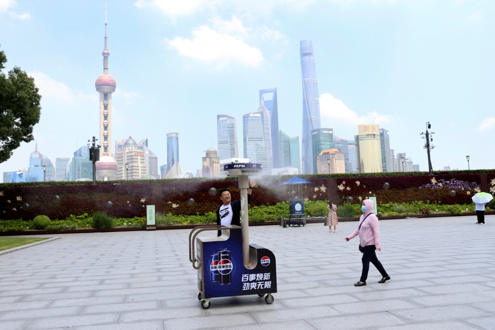 Pedestrians walk past a misting machine on The Bund, during an orange alert for heatwave in Shanghai. Photo: Reuters