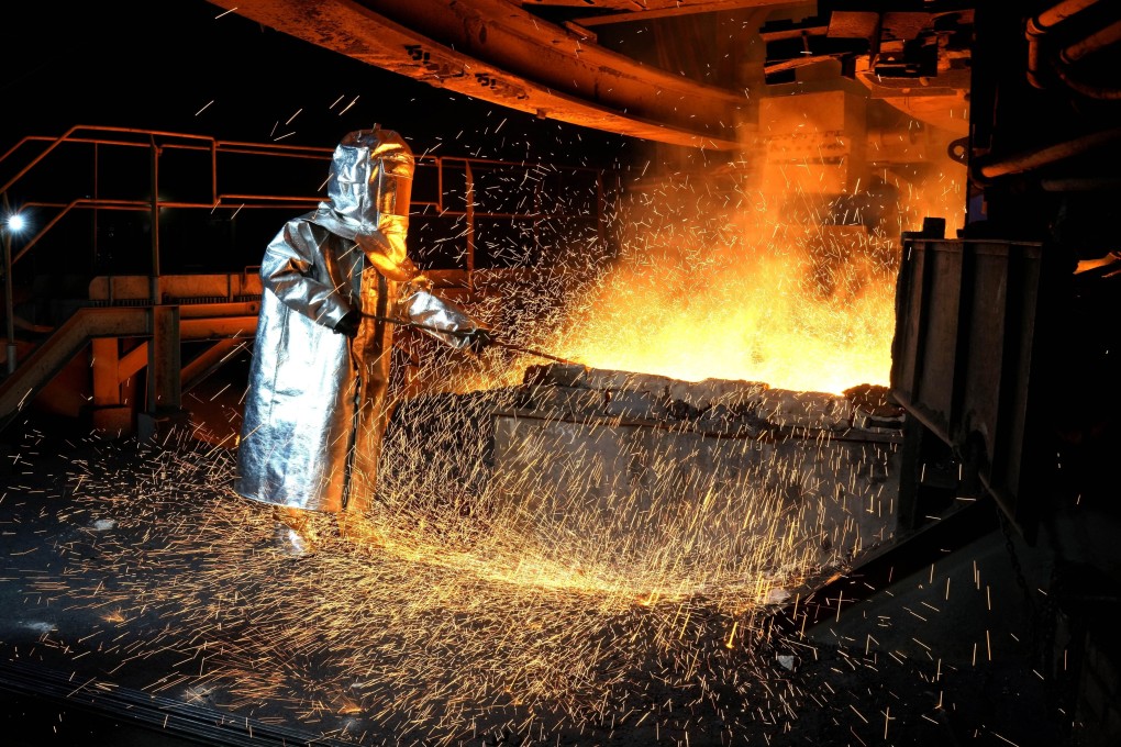 A worker in a protective suit pokes a metal rod to tap slag from a smelting furnace at PT Vale Indonesia’s nickel processing plant in Sorowako, South Sulawesi, Indonesia, Photo: (AP Photo/Dita Alangkara)