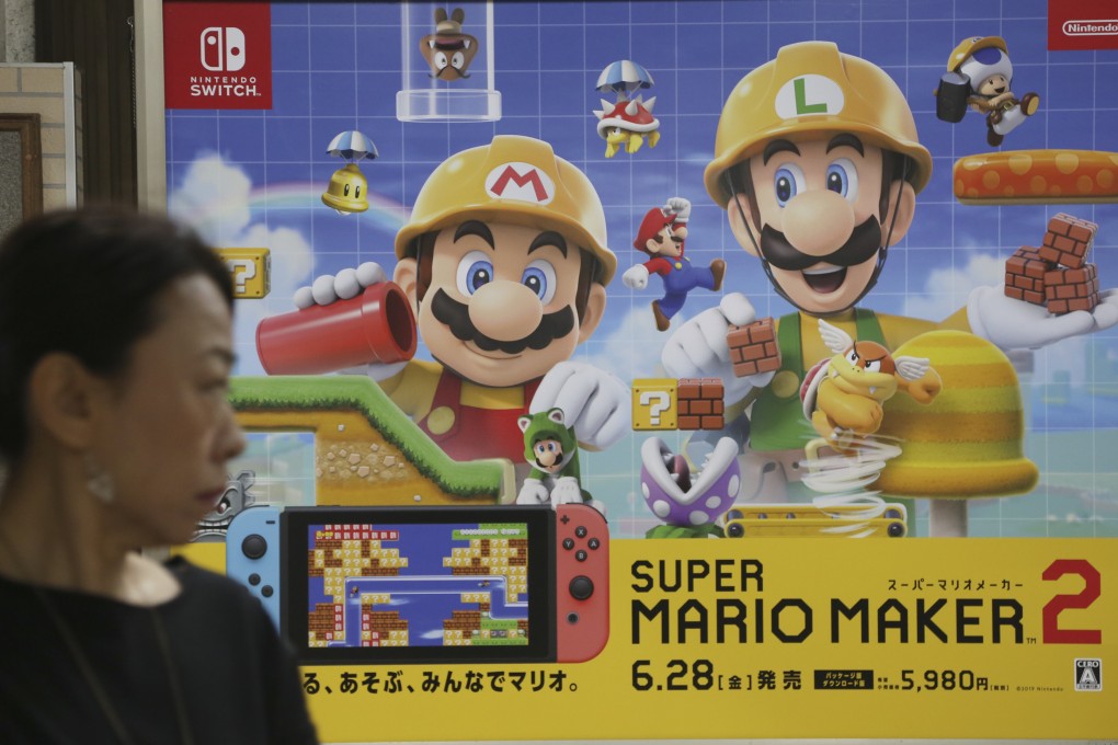 A woman walks by a Nintendo advertisement for the game Super Mario Maker 2 on the Switch in Tokyo on July 9, 2019. Photo: AP