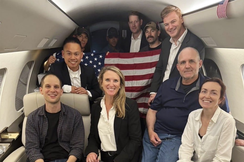 Evan Gershkovich, left, Alsu Kurmasheva, right, and Paul Whelan, second from right, and others aboard a plane on Thursday following their release from Russian captivity. Photo: White House via AP