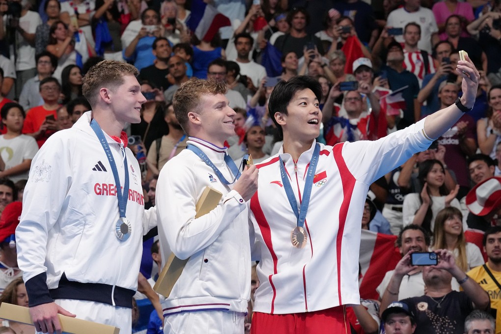 China’s bronze medallist Wang Shun (right) shares a selfie with Leon Marchand (centre), who won gold and Great Britain’s Duncan Scott (left). Photo: Xinhua