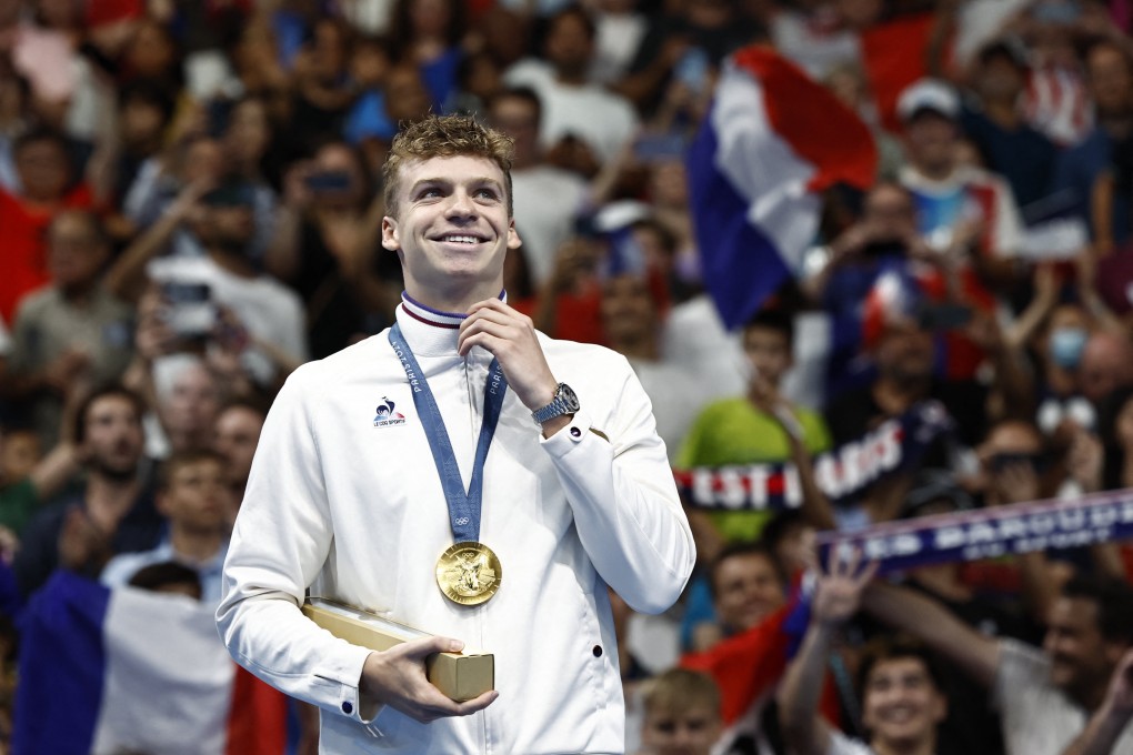 Leon Marchand of France collects gold for the 200 metres individual medley. Photo: Reuters