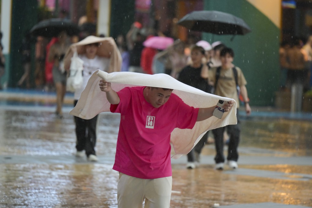 People walk on a waterlogged road in the rain in Guangzhou, Guangdong province, China, on April 20, 2024. Photo: China News Service/VCG via Getty Images