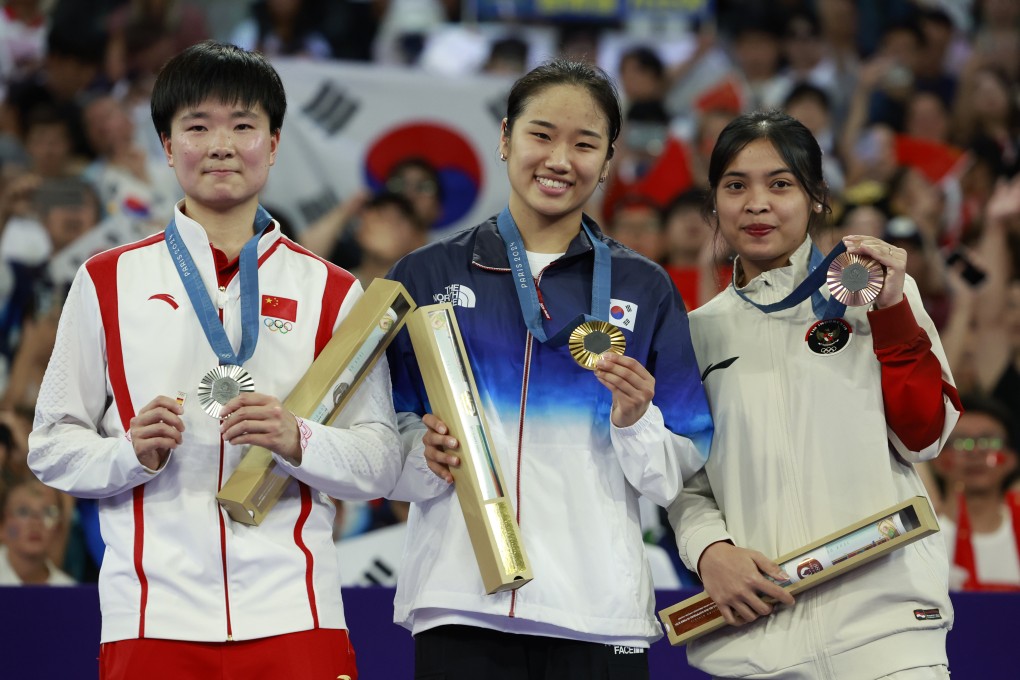 China’s He Bingjiao (left) holds a small pin of the Spanish flag in her right hand while standing on the podium next to An Se-young (centre) and Gregoria Mariska Tunjung: Photo: Xinhua
