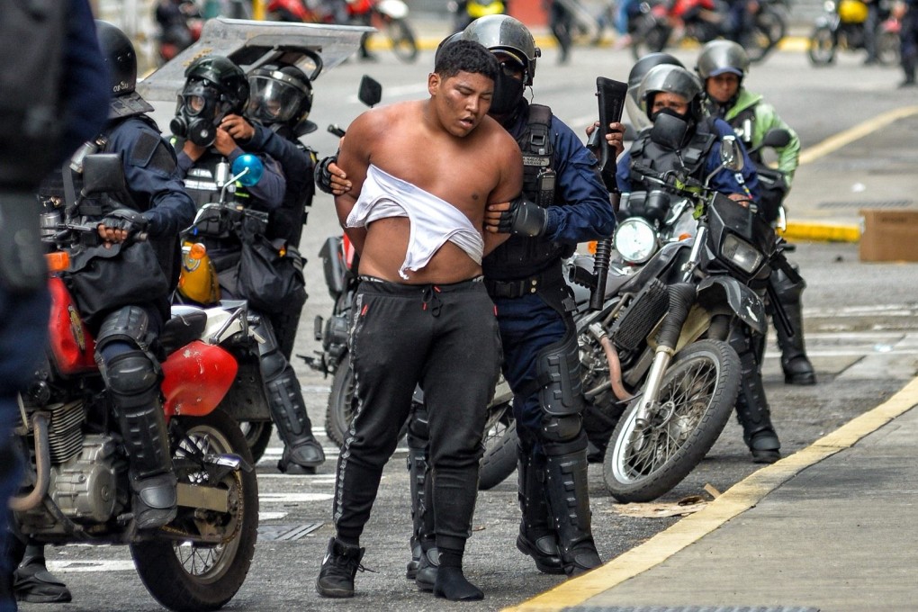 Members of the Bolivarian National police riot squad arresting a man in Caracas, Venezuela last Tuesday. Photo: AFP