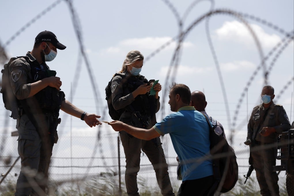 Israeli security forces checking Palestinians IDs as they stand in line on their way back to the West Bank in September 2021. Photo: EPA-EFE