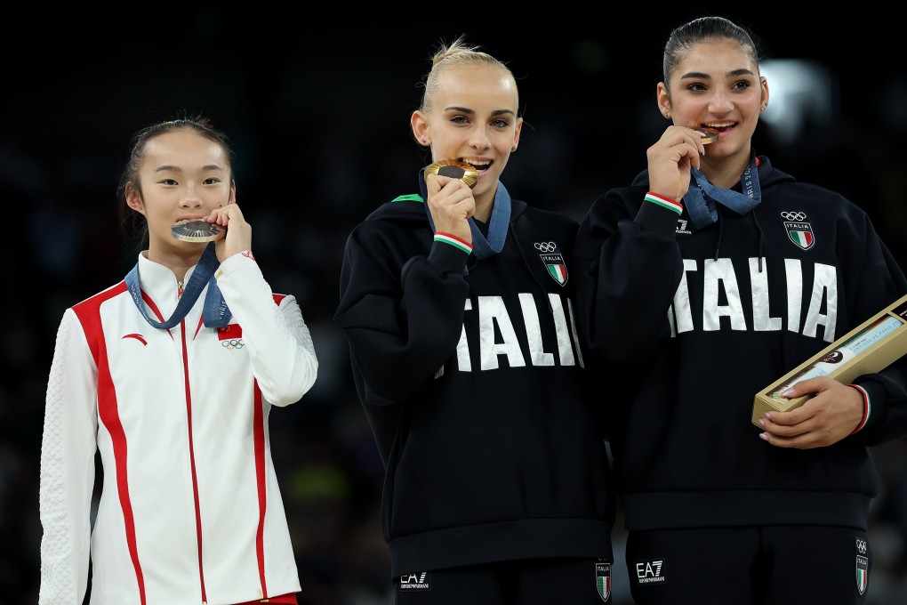 Zhou Yaqin (left), lightly bites her silver medal as she adorably mimics gold medallist Alice D’Amato (centre) and Manila Esposito, who won bronze. Photo: Xinhua