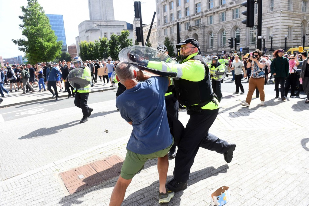 An officer tries to restrain a protester in Liverpool on August 3. The demonstrations were triggered by a mass stabbing incident. Photo: AFP