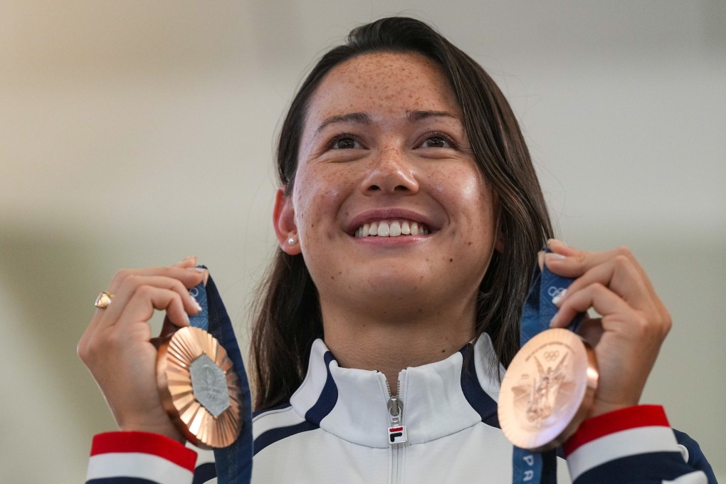 Olympic swimming star Siobhan Haughey holds up her medals as she arrives in Hong Kong. Photo: Elson Li