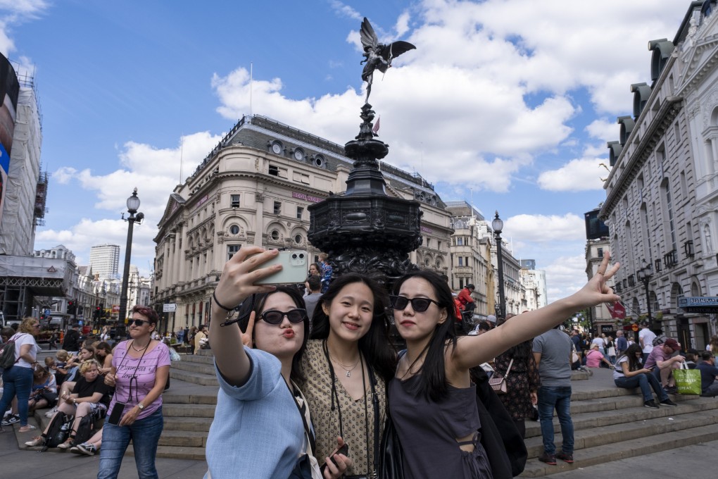 Tourists take a selfie at Piccadilly Circus in London. Photo: Getty Images