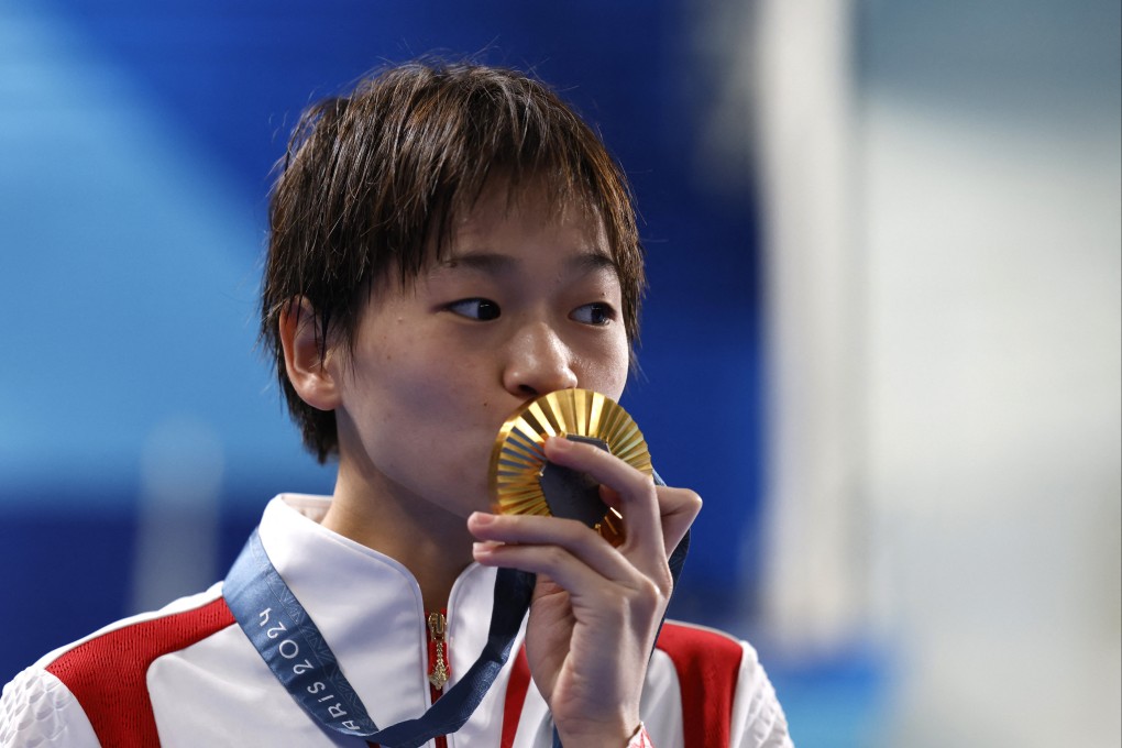 China’s Quan Hongchan kisses her gold medal after winning her third at the Olympics during the Paris Games. Photo: Reuters