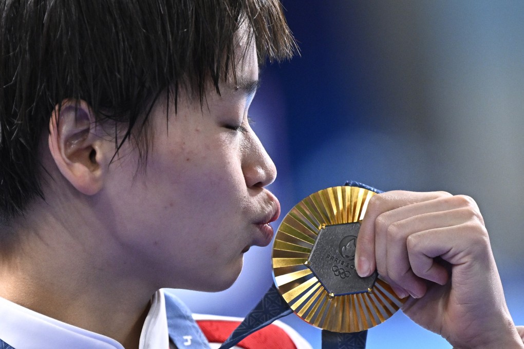 Quan Hongchan kisses her gold medal after winning the women’s 10m platform final. Photo: Xinhua