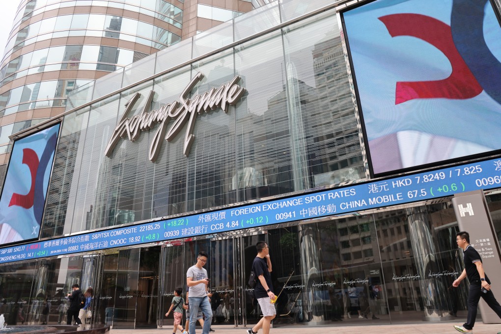 People walking outside the Exchange Square in Central, with boards showing Hong Kong stock prices in April 2024. Photo: Jelly Tse.