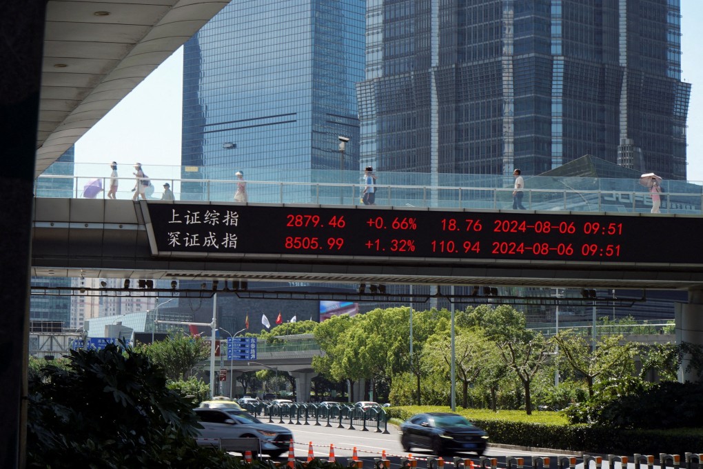 People walk on an overpass with a display of stock information in the Lujiazui financial district in Shanghai on August 6. Photo: Reuters