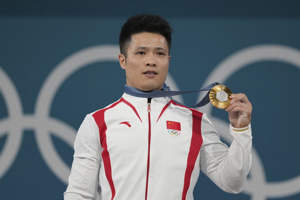 Li Fabin of China wears his gold medal for the men’s 61kg weightlifting. Photo: AP