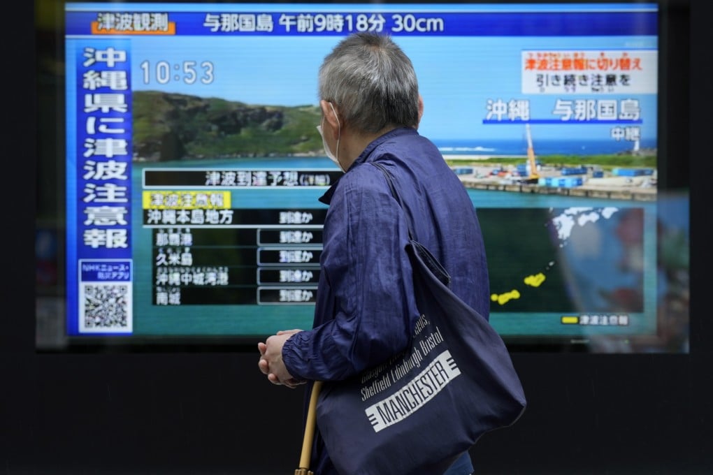 A person watches breaking news on a tsunami in Tokyo in April. Japan issued tsunami alerts after a 6.9-magnitude earthquake struck, followed by a 7.1 tremor on Thursday. Photo: AP