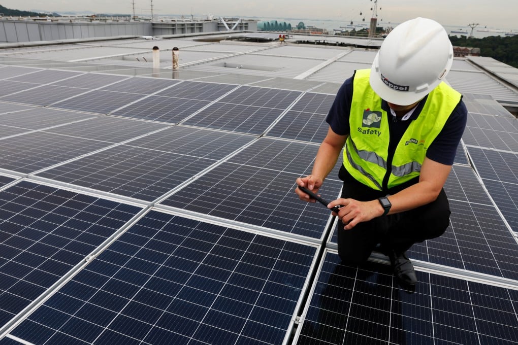 A Keppel employee poses for photos during a tour of their rooftop solar panels at their Keppel Bay Tower office building in Singapore. REUTERS/Edgar Su