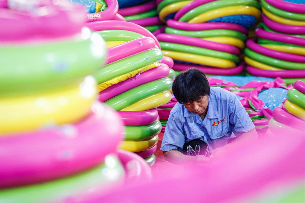 An employee works on inflatable swimming products for export at a factory in Suqian, in eastern China’s Jiangsu province. Photo: AFP
