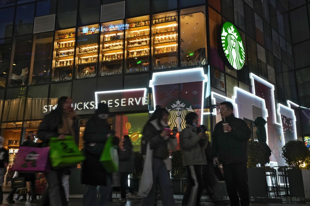 Shoppers walk by a Starbucks cafe at an outdoor shopping mall in Beijing on December 23, 2023. Photo: AP