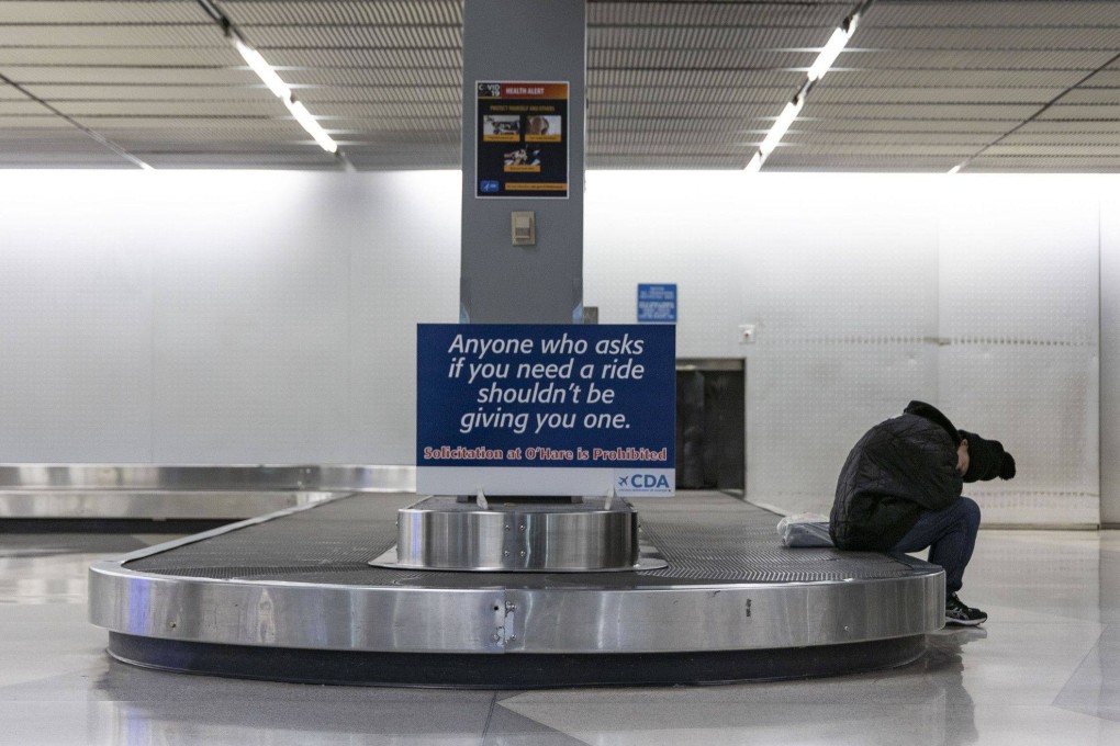 A person sleeps at the baggage claim area at Chicago’s O’Hare International Airport in January 2023. Photo: Chicago Tribune via TNS