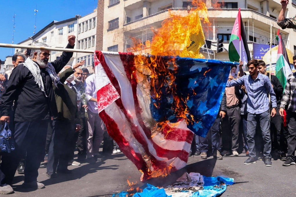 Protesters burn a US and an Israeli flag in Tehran. The report does not specify Iran’s intentions besides sowing chaos in the US. Photo: AFP