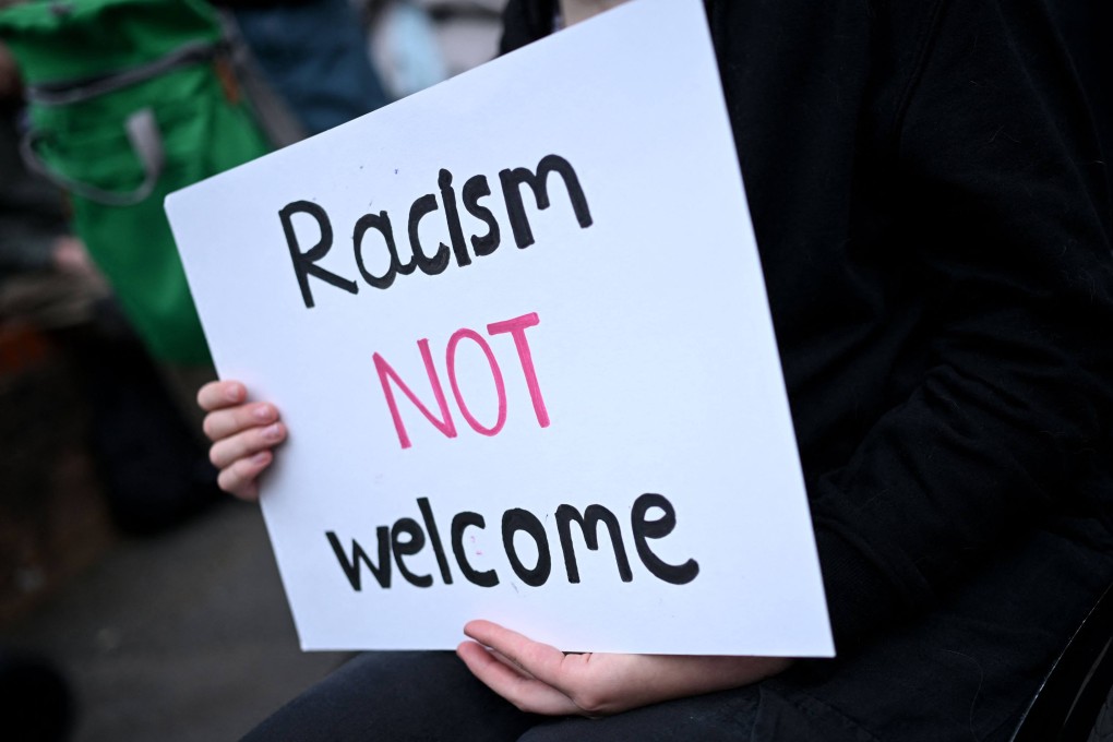 A protester holds a sign during a counter-demonstration against an anti-immigration protest linked to the Southport killings called by far-right activists in Oxford, England on August 7, 2024. The anti-immigration protests highlight a similar mentality to that which resulted in the murder of thousands of foreigners in China in the wake of the Ispah rebellion. Photo: AFP
