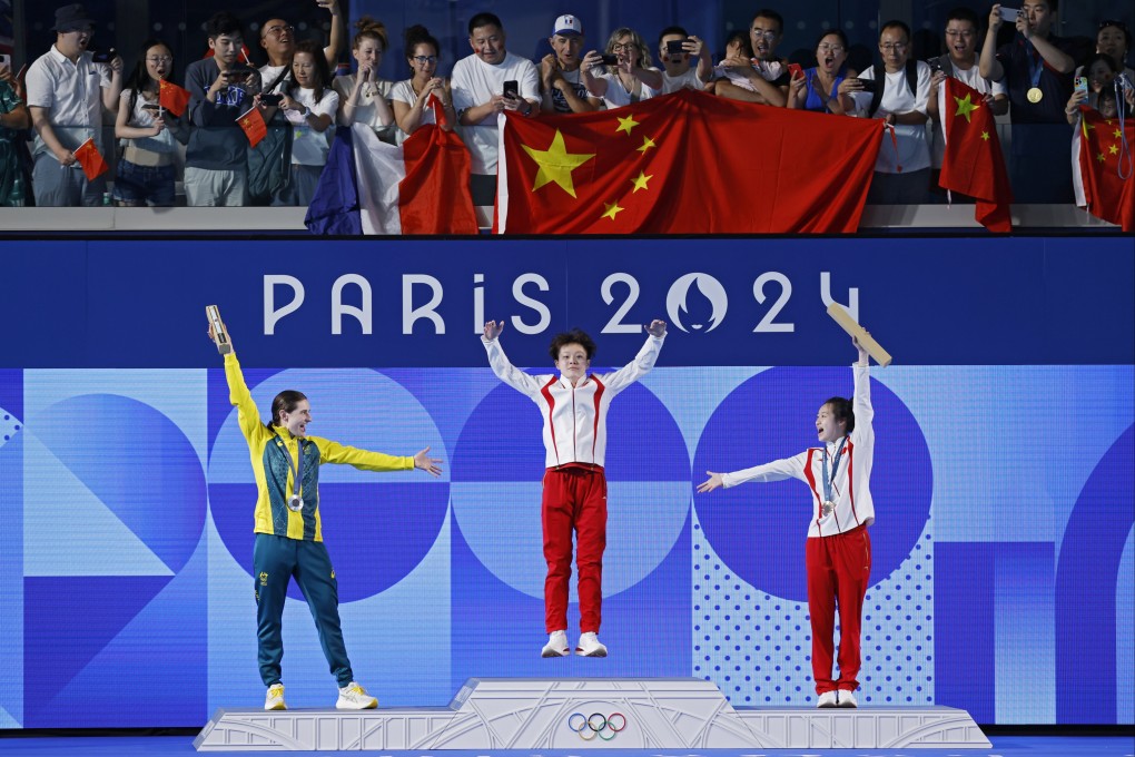 Chen Yiwen is hailed by fellow Chinese Chang Yani (right) and silver medallist Maddison Keeney (left), as she leaps onto the top of the podium at Paris Aquatics Centre. Photo: EPA.