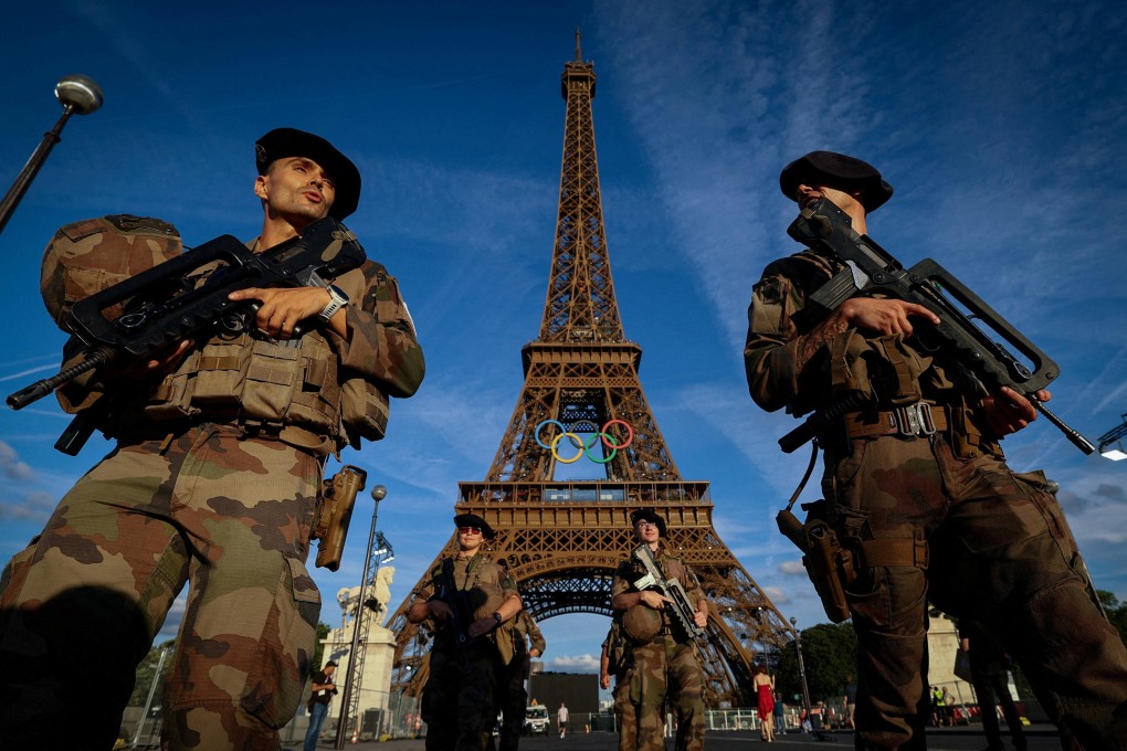 Soldiers patrol a street in front of the Eiffel Tower. On Sunday, a man was arrested after he was seen climbing the Paris landmark. Photo: Reuters