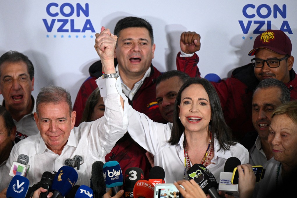 Venezuelan opposition leader Maria Corina Machado, right, raises the arm of opposition presidential candidate Edmundo Gonzalez Urrutia in Caracas on July 28. Photo: AFP / Getty Images / TNS