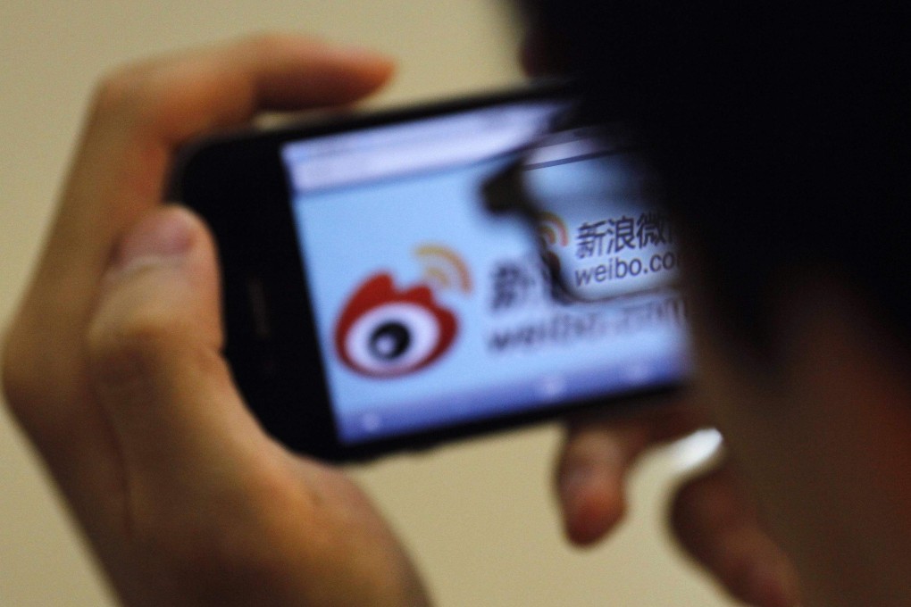 A man holds an iPhone as he visits Sina’s Weibo microblogging site in Shanghai on May 29, 2012. Photo: Reuters