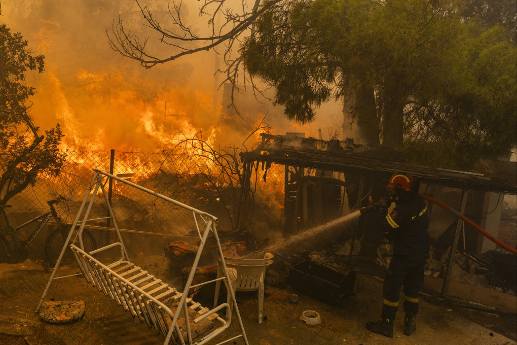 A firefighter works to extinguish a large fire outside Athens, Greece on Monday. Photo: dpa