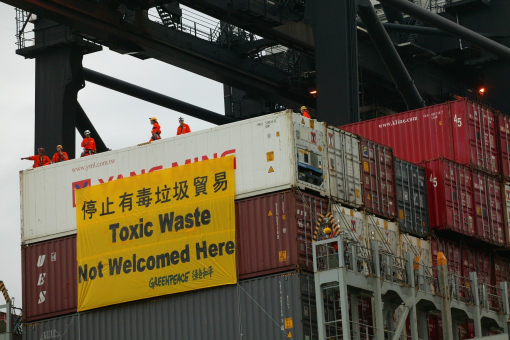 Greenpeace activists hang a banner on a cargo container loaded with electronic waste during a demonstration. Containers bound for Thailand allegedly filled with tons of hazardous industrial waste from Albania are now slated to return to Europe. Photo: SCMP/File