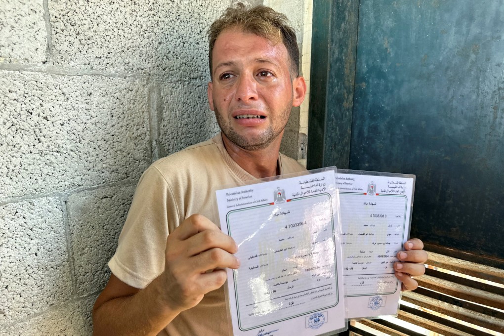 Mohammed Abu al-Qumsan, whose wife and newborn twins were killed in an Israeli strike, holds the babies’ birth certificates at the hospital in Gaza on Tuesday. Photo: Reuters