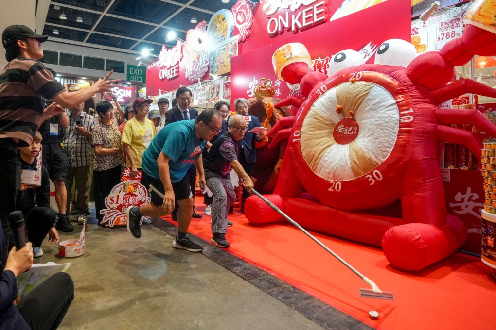 Contestants test their throwing arms in a bid to win 500 cans of abalone on the first day of the Hong Kong Food Expo. Photo: Sam Tsang