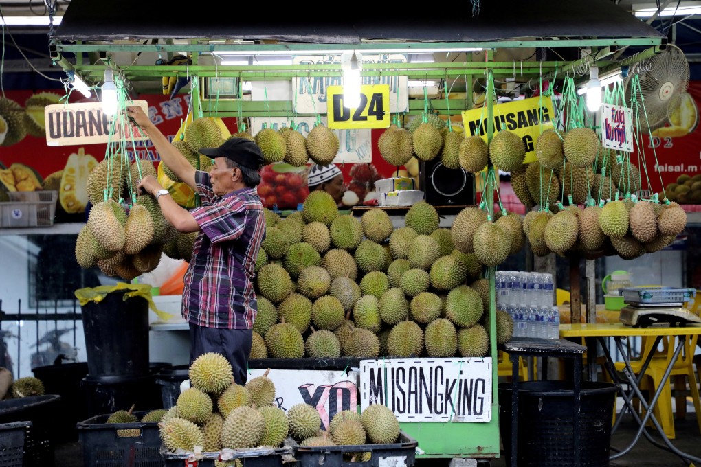 A man arranges durians at a stall in Kuala Lumpur. China’s reforms are expected to stimulate economic growth, and stronger economic performance in China typically results in higher demand for Malaysian exports. Photo: Reuters