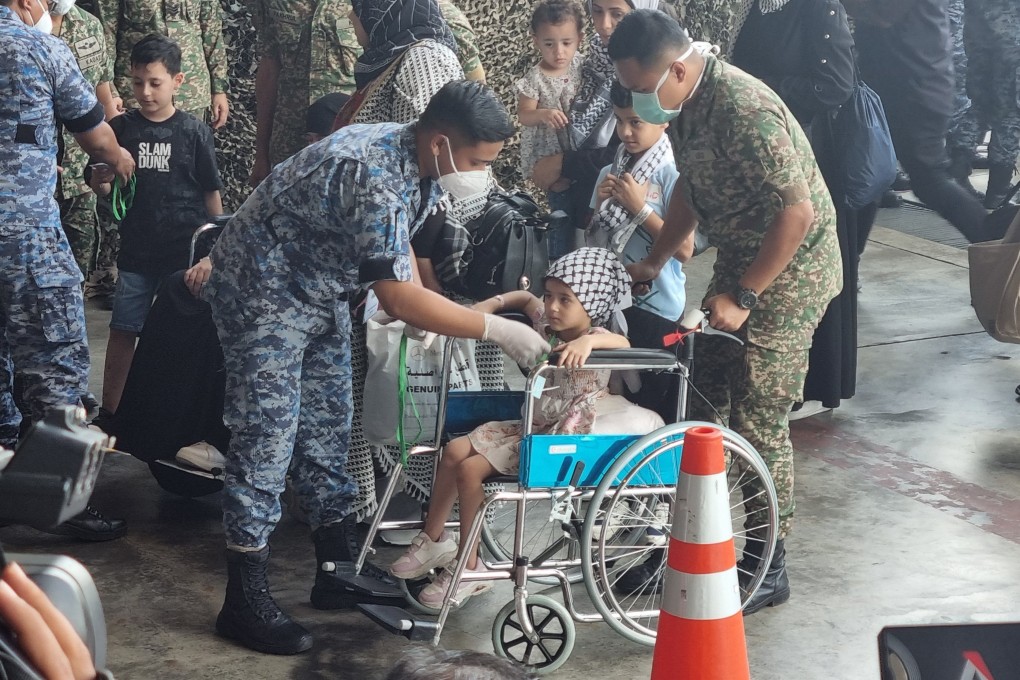 Malaysian armed forces personnel escort patients and families that fled the Israel-Gaza war, into a field hospital at the Subang air force base. Photo: Joseph Sipalan