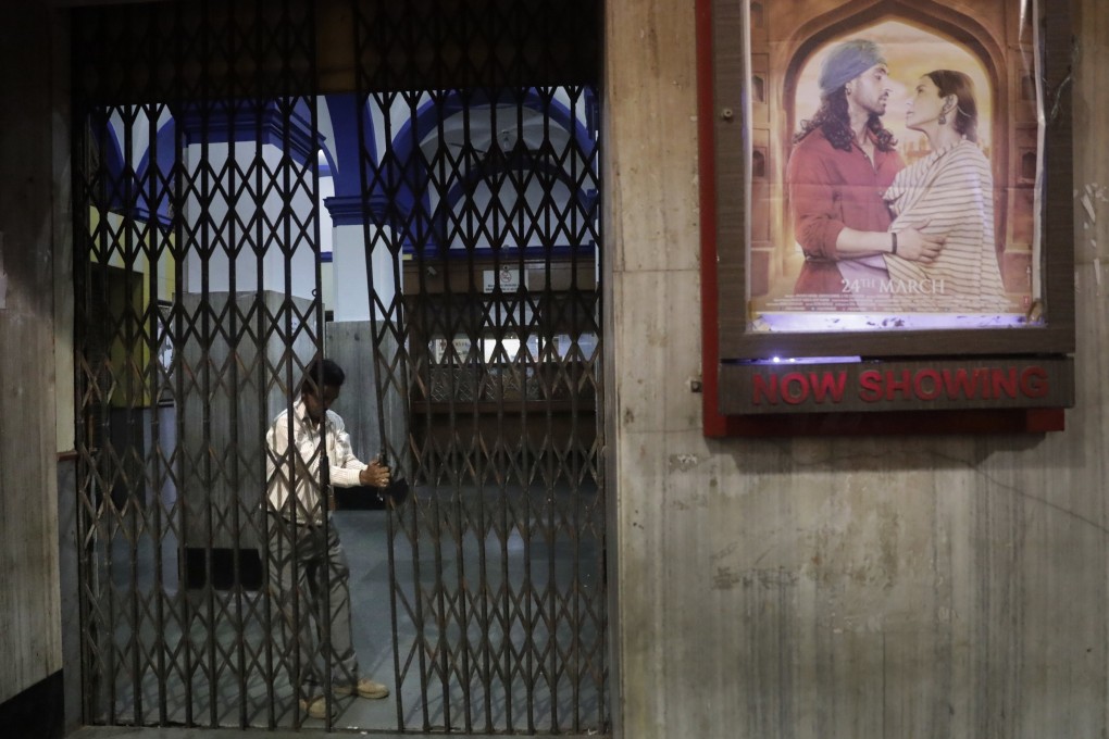 A guard locks the gate at the Regal Theatre in New Delhi after its final-ever screening in 2017. Across India, cinema halls are closing at an alarming rate. Photo: AP