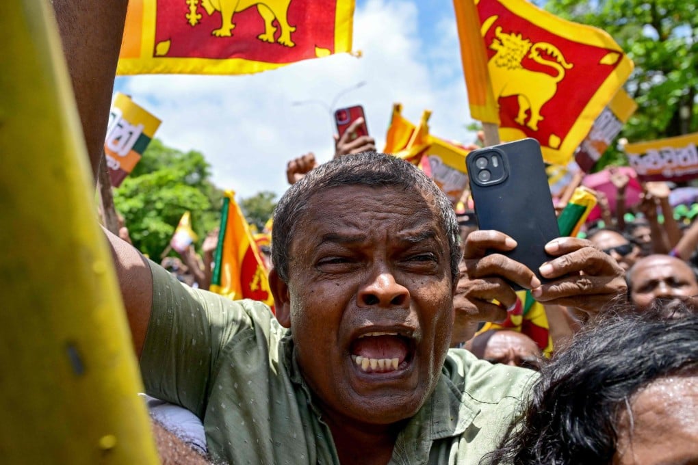 Supporters of Sri Lanka’s President Ranil Wickremesinghe cheer in Colombo on August 15 after he filed his papers for the coming presidential elections. Photo: AFP