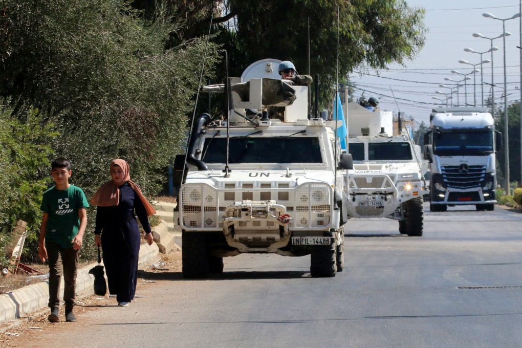 People walk near UN peacekeepers (UNIFIL) vehicles in Marjayoun, near the border with Israel, in southern Lebanon on August 9, 2024. Photo: Reuters