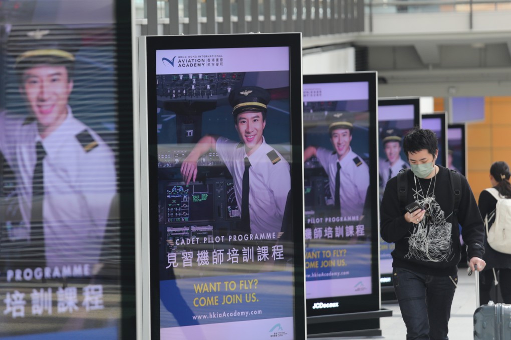 People walk past pilot recruitment advertisements at Hong Kong International Airport on January 10. Photo: Xiaomei Chen