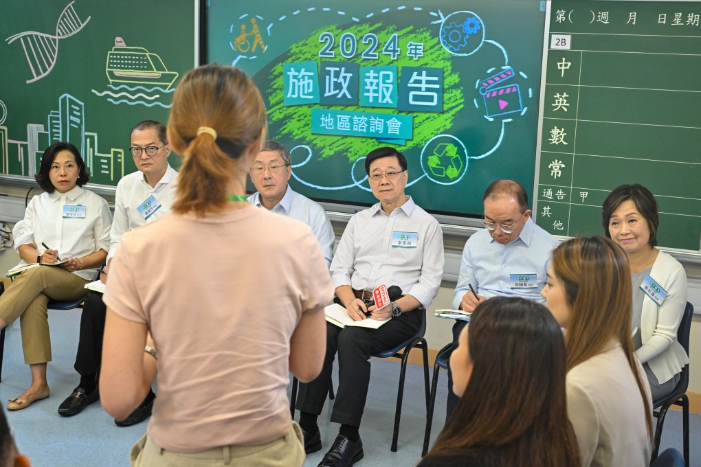 John Lee (third from right) listens to a member of the public at the 2024 Policy Address District Forum alongside other prinicpal officials on Sunday. Photo: ISD