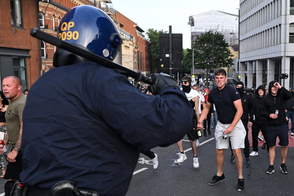 Riot police face protestors in southern England, on August 3, during the ‘Enough is Enough’ demonstration held in reaction to the fatal stabbings in Southport on July 29. Photo: AFP