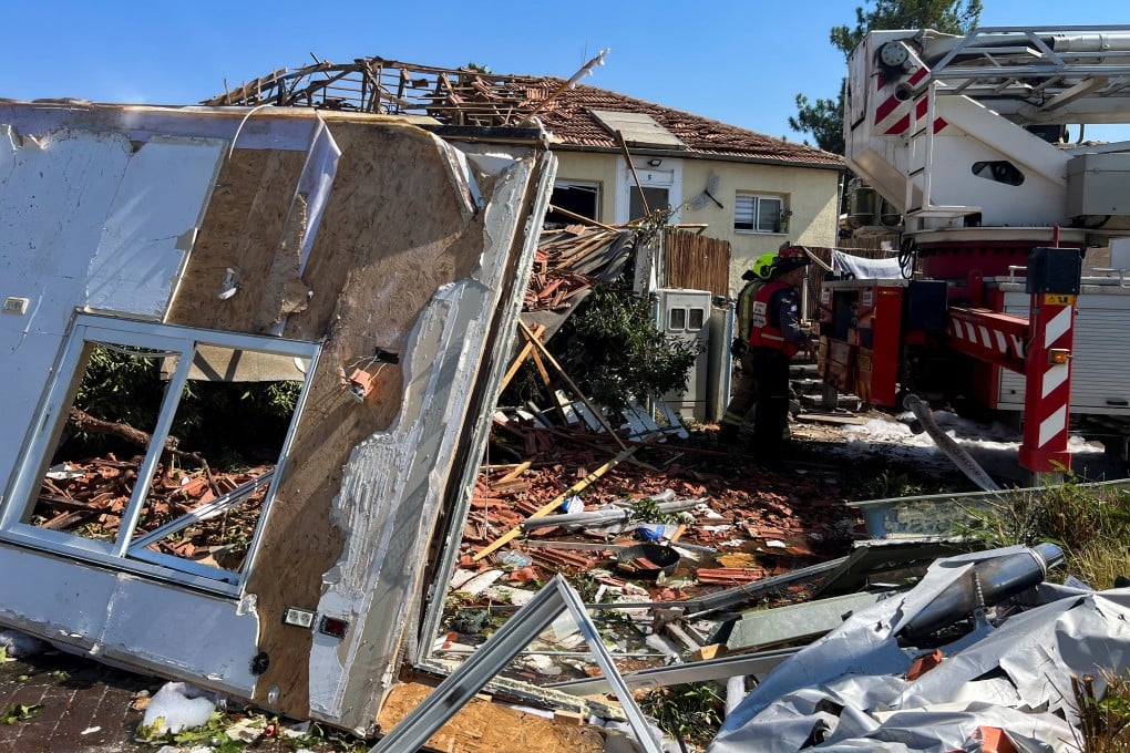 Firefighters work at the site of a house that was damaged after rockets were fired from Lebanon, amid cross-border hostilities between Hezbollah and Israel, in the Israeli-occupied Golan Heights, on Wednesday. Photo: Reuters
