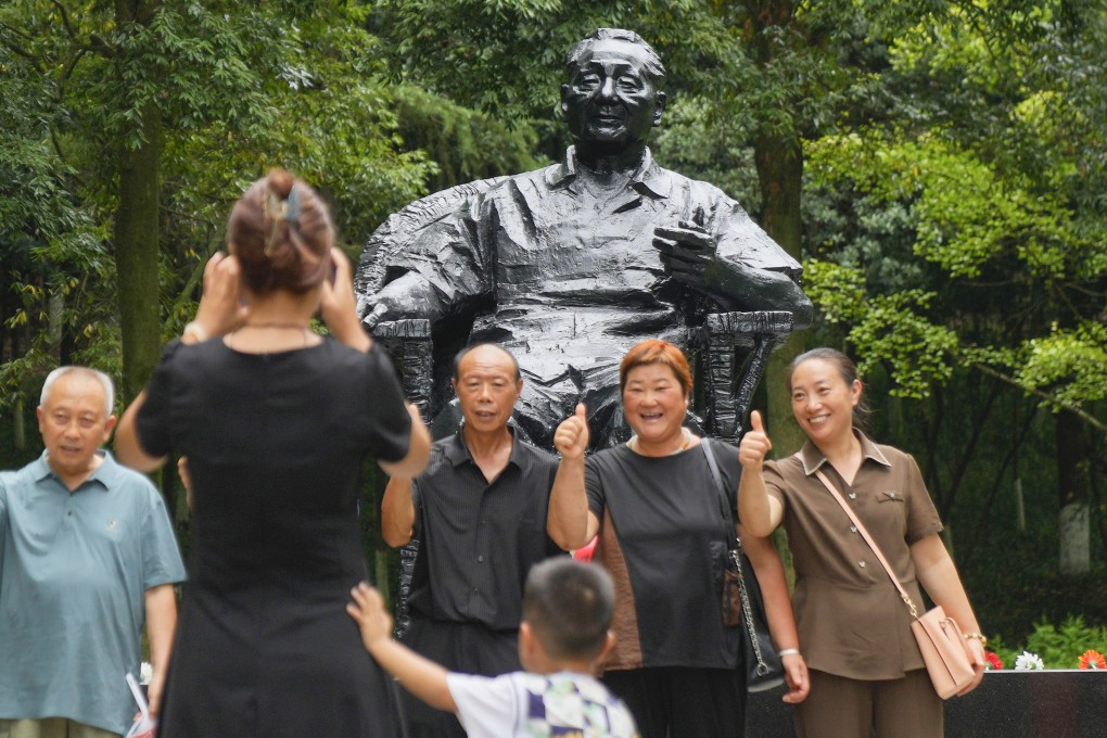 Tourists pose for a photo in front of a bronze statue of the late Chinese leader Deng Xiaoping near his birthplace in Guangan, Sichuan province, on August 14. Photo: Kyodo