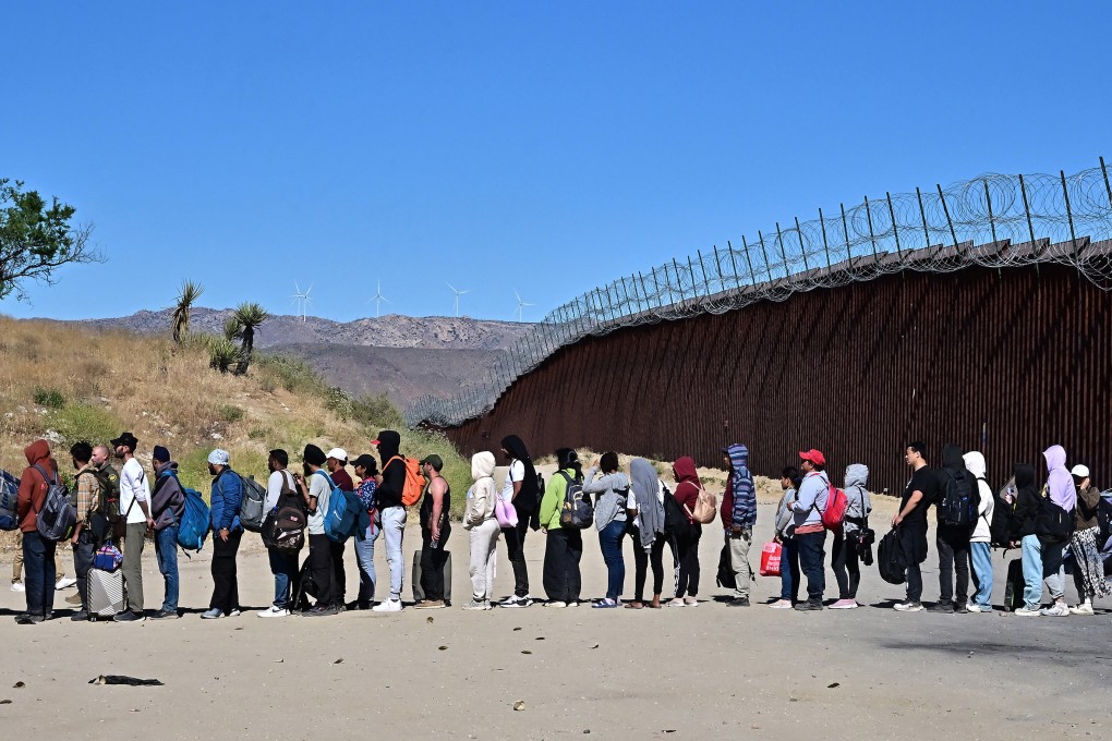 Migrants wait in line hoping for processing from US Customs and Border Patrol agents after arriving in California from Mexico. Photo: AFP/Getty Images/TNS